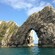 A crowded beach on the Jurassic Coast is situated next to the Durdle Door natural limestone arch